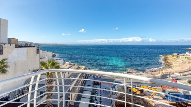 Vista da costa a partir de uma varanda com vista para um canteiro de obras e o mar.