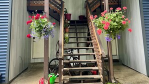 A wooden staircase with railings, leading to a door. - Urban Comfort with Northern Charm (Anchorage)