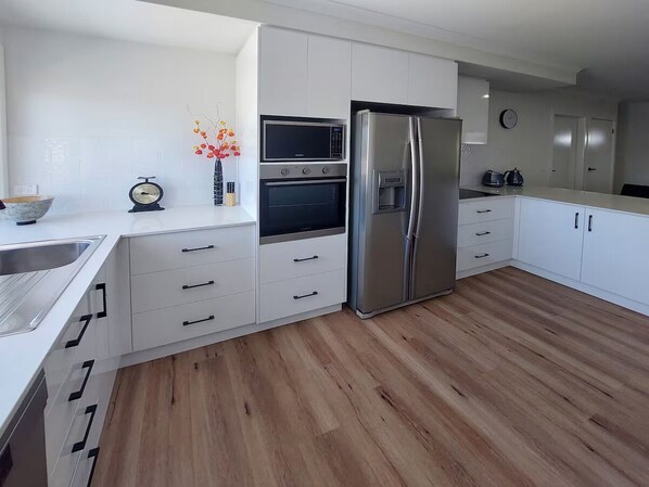 Enjoy cooking in this well-equipped kitchen with sleek cabinetry, a refrigerator, and oven.