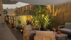 An outdoor patio area with wooden furniture, potted plants, and a large canopy providing shade. - Quiet Algarve villa near Albufeira & branches with prívate pool BBQ terrace (Algoz)