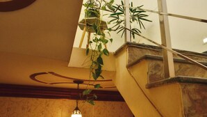 A staircase with a hanging plant and a light fixture. - 15 minutes to the Harkipauri! Manstays 3 bedroom condo with Balcony & parking! (Haridwar)