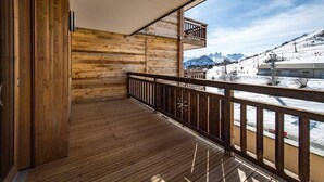 A wooden balcony with a view of a snowy mountain landscape. - Apartment for 8 people in a new residence on the slopes (LA TOUSSUIRE)