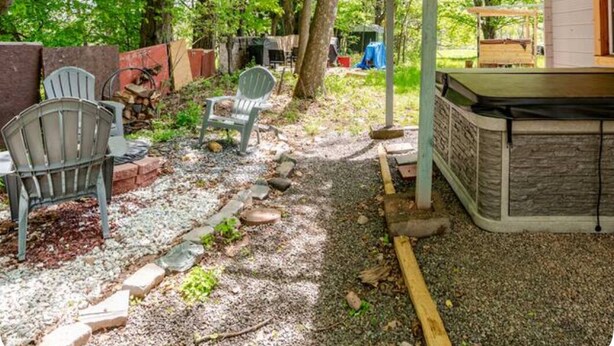 An outdoor patio area with a pergola, seating, and a barbecue grill. - The Cozy Cabins at Walnut Grove- Your Perfect Getaway near Hunter/ Windham (Ashland)