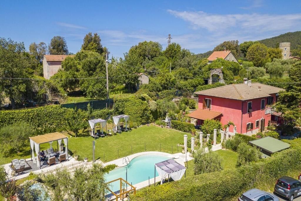 Il s’agit d’une propriété résidentielle dotée d’une piscine, d’un belvédère et d’un bâtiment rouge.