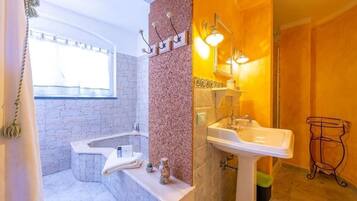 A bathroom with a bathtub, a sink, and a mirror.