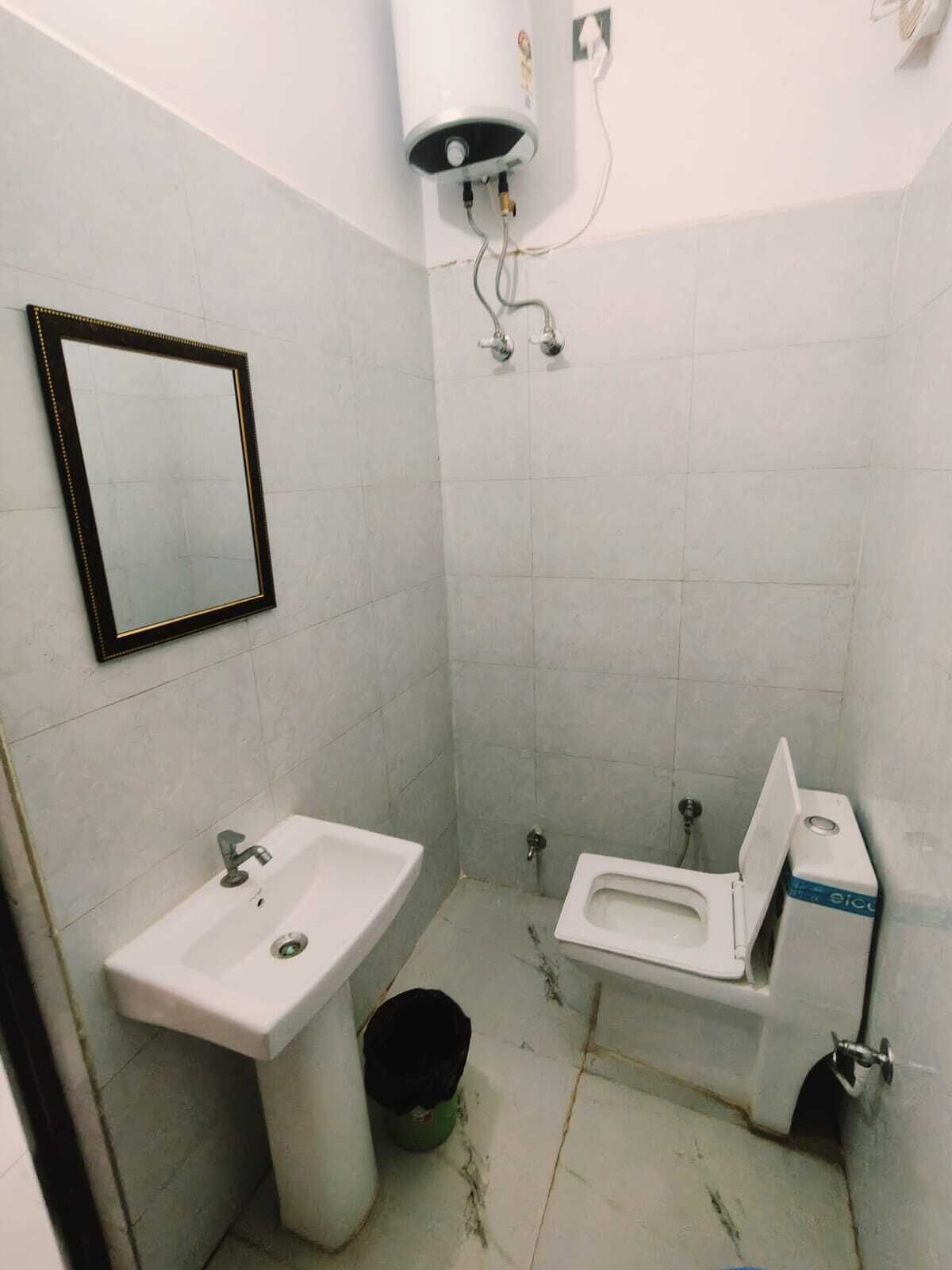 A small bathroom with a sink, toilet, and mirror.