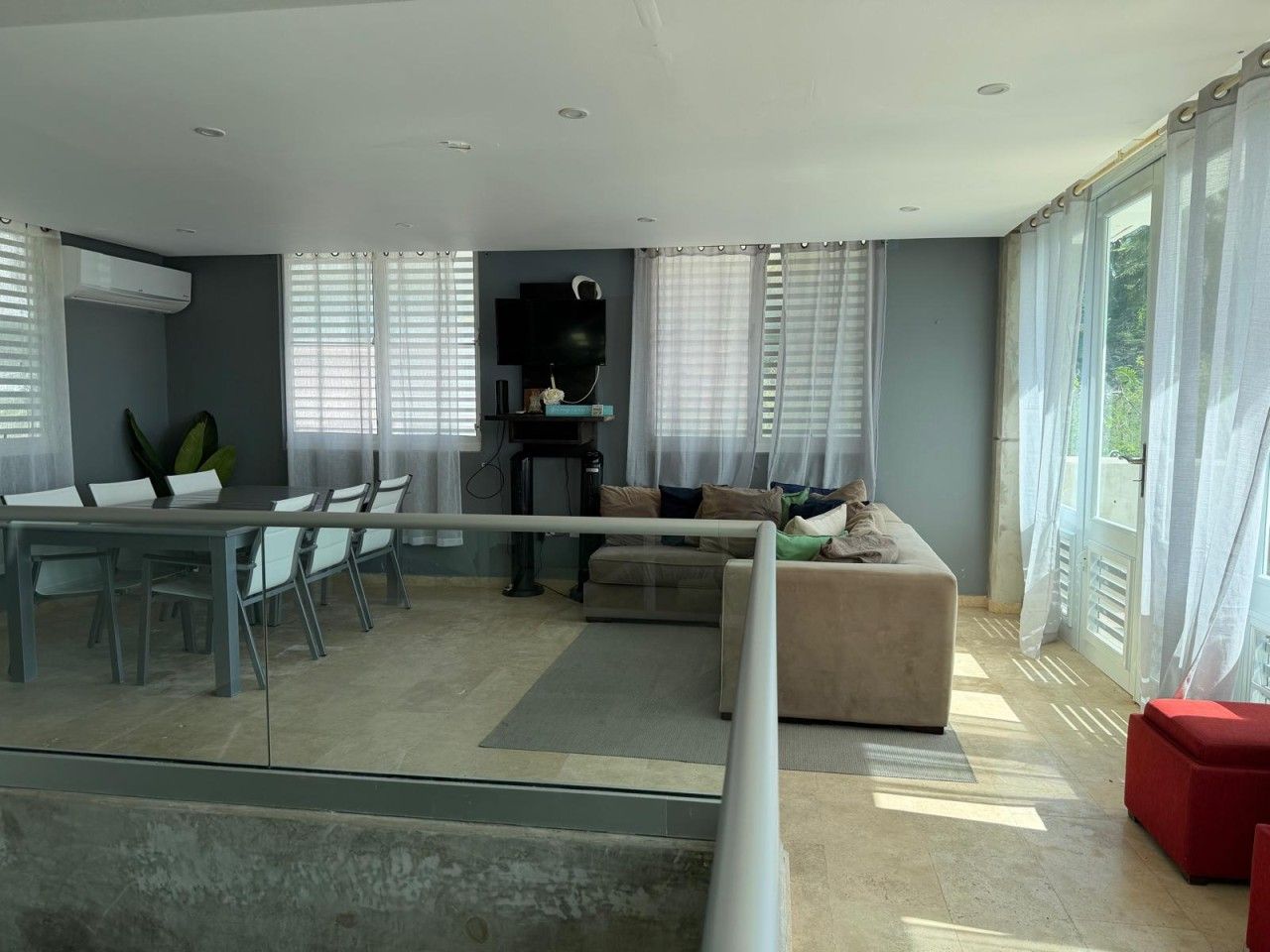 En moderne stue med spiseplads, sofa og fjernsyn.