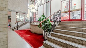 Una escalera con alfombra roja, una zona de estar circular y vistas de scooters estacionados afuera.