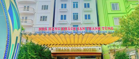 Entrada de un hotel con un cartel que dice "NHA HANG HACH SAN THANH TUNG HOTEL".