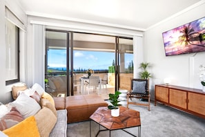 A modern living room with a sofa, coffee table, and a view of the outdoors.