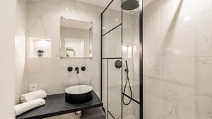 A modern bathroom with a glass-enclosed shower, a black countertop, and a white sink. - Appartement Confort & Serenite 2bdr/4p (Cannes)