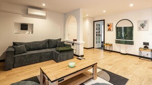 A modern living room with a sectional sofa, a wooden coffee table, and a small side table. - Appartement Confort & Serenite 2bdr/4p (Cannes)