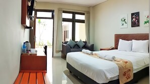 Une chambre d’hôtel comprenant un lit, un canapé, un bureau avec une chaise et une fenêtre avec des rideaux.