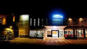 Un hôtel moderne, doté d’une enseigne bien visible, d’une entrée bien éclairée et d’une allée pavée.