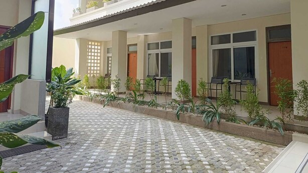 Un hôtel doté d’un espace extérieur abrité, de plantes en pot et d’un sol carrelé.