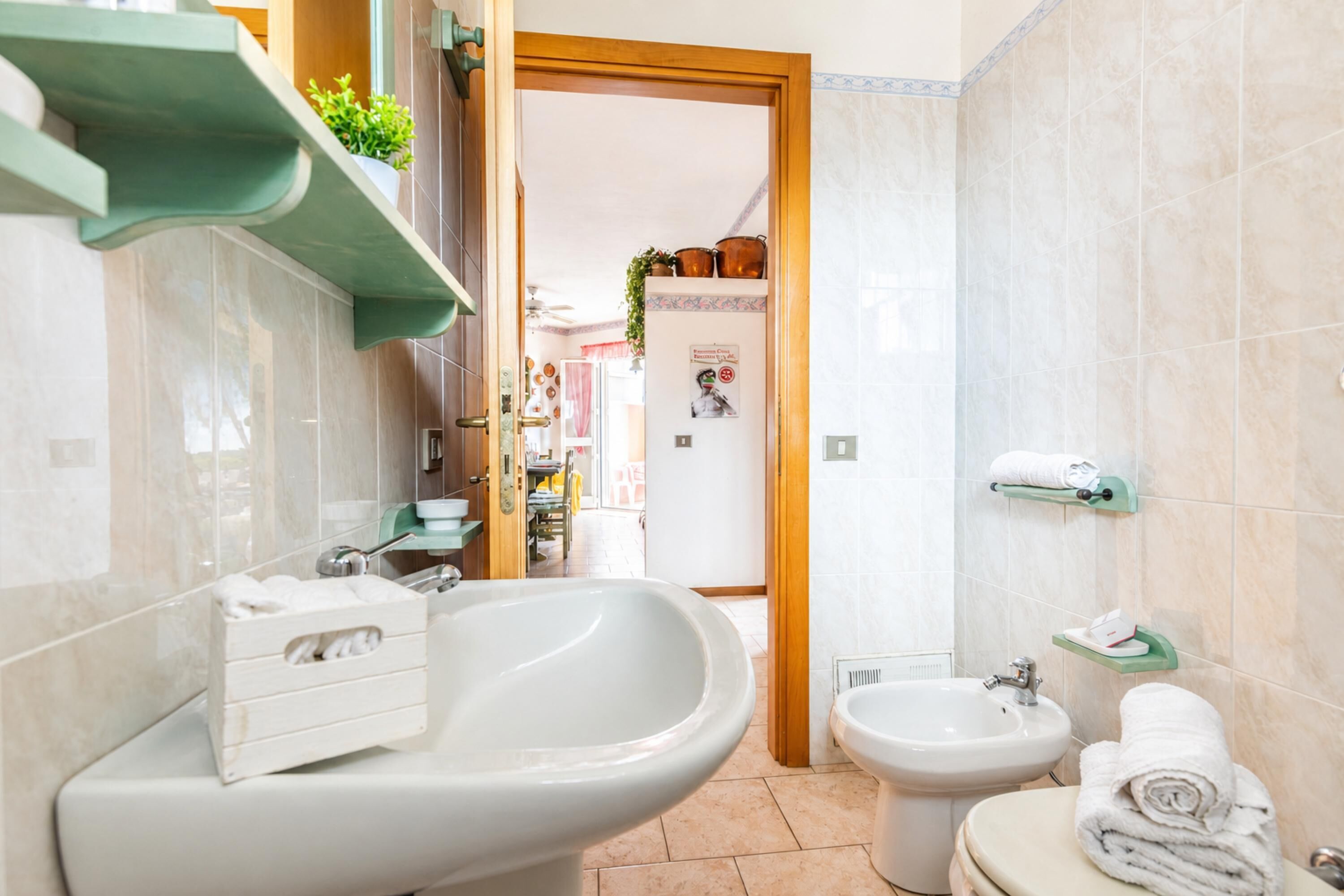 A bathroom with a sink, bidet, and toilet.