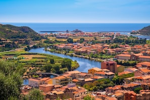 A coastal town with terracotta-roofed buildings, a river, and a bridge. - Residence 4 Colonne (Bosa)