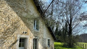 A rustic stone building with a sloped roof, a bench outside, and a grassy area with a fence. - Charming gite not far from the Orval Abbey (Orval)