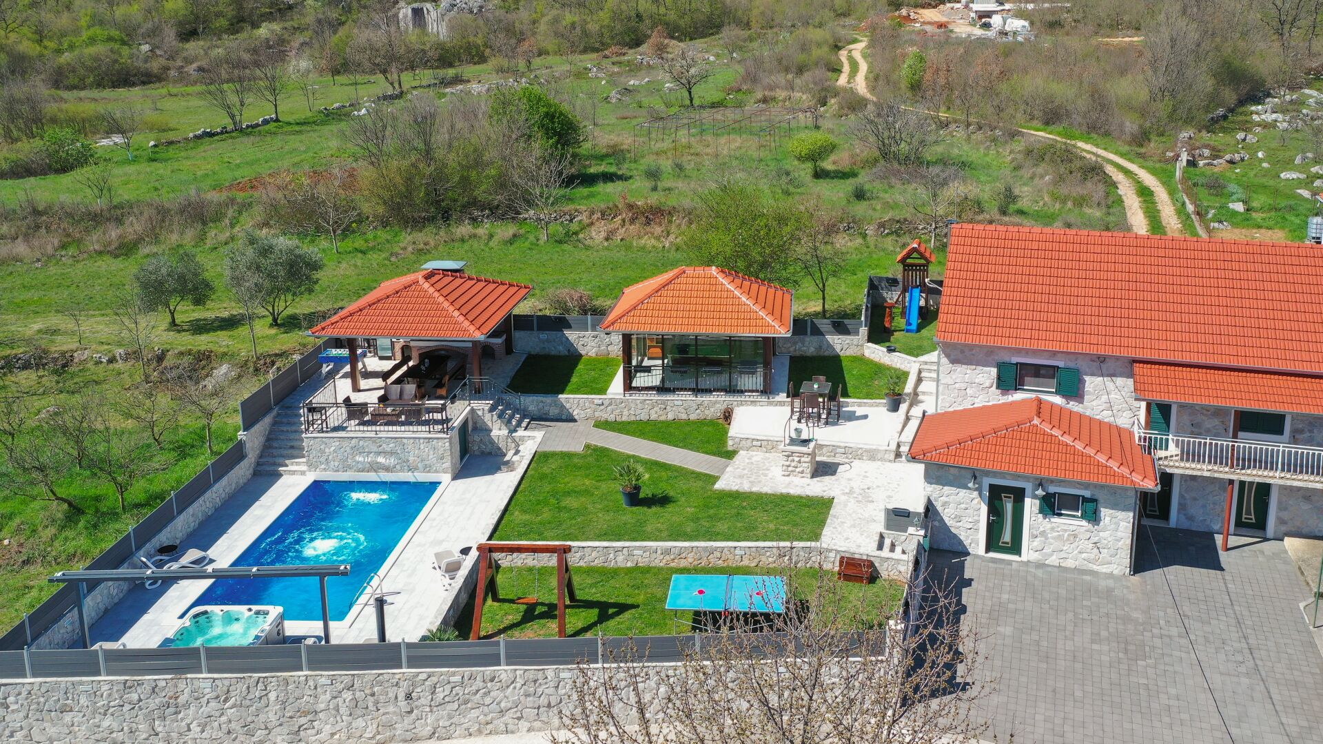 A residential property with a swimming pool, outdoor seating, and a stone pathway.