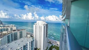 A high-rise building with a view of the ocean and other buildings.