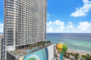 A high-rise hotel with multiple balconies and a pool area.