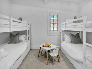 A room with bunk beds, a small table with toys, and a window with blinds. - Conifer - Pet Friendly with Outdoor Spa (Callala Beach)