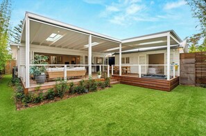A modern house with a covered patio, a hot tub, and a well-maintained lawn. - Conifer - Pet Friendly with Outdoor Spa (Callala Beach)