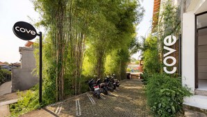 A paved pathway leading to a building with a sign reading 'Cove.' - Cove Wong Village (Tumbak Bayuh)