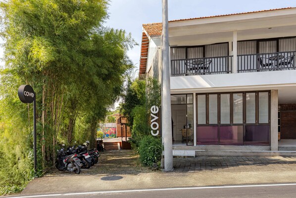 Un edificio con un letrero que dice 'cove', un área de estar al aire libre techada y una fila de motocicletas estacionadas.