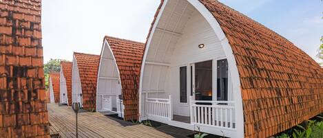 A row of bungalow-style cabins with pitched roofs and white railings.
