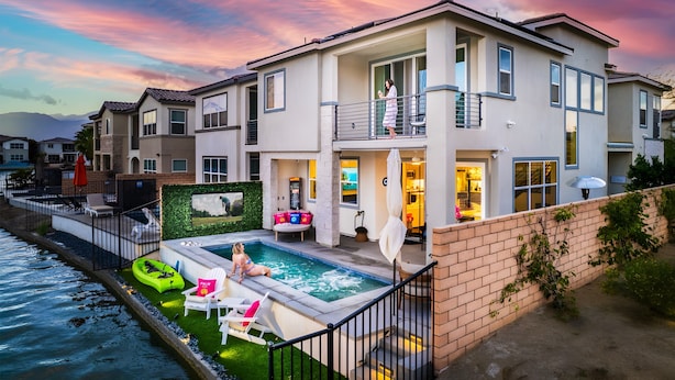A modern two-story house with a swimming pool, a balcony, and a well-maintained garden.