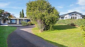 A pathway leading to a building with a paved entrance and a well-maintained lawn.