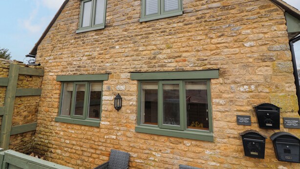 A stone building with multiple windows and mailboxes. - Triumph Cottage (Chipping Norton)
