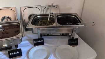 Un bufé con platos identificados, incluyendo Rosenkohl, Roulade y Potkohl.