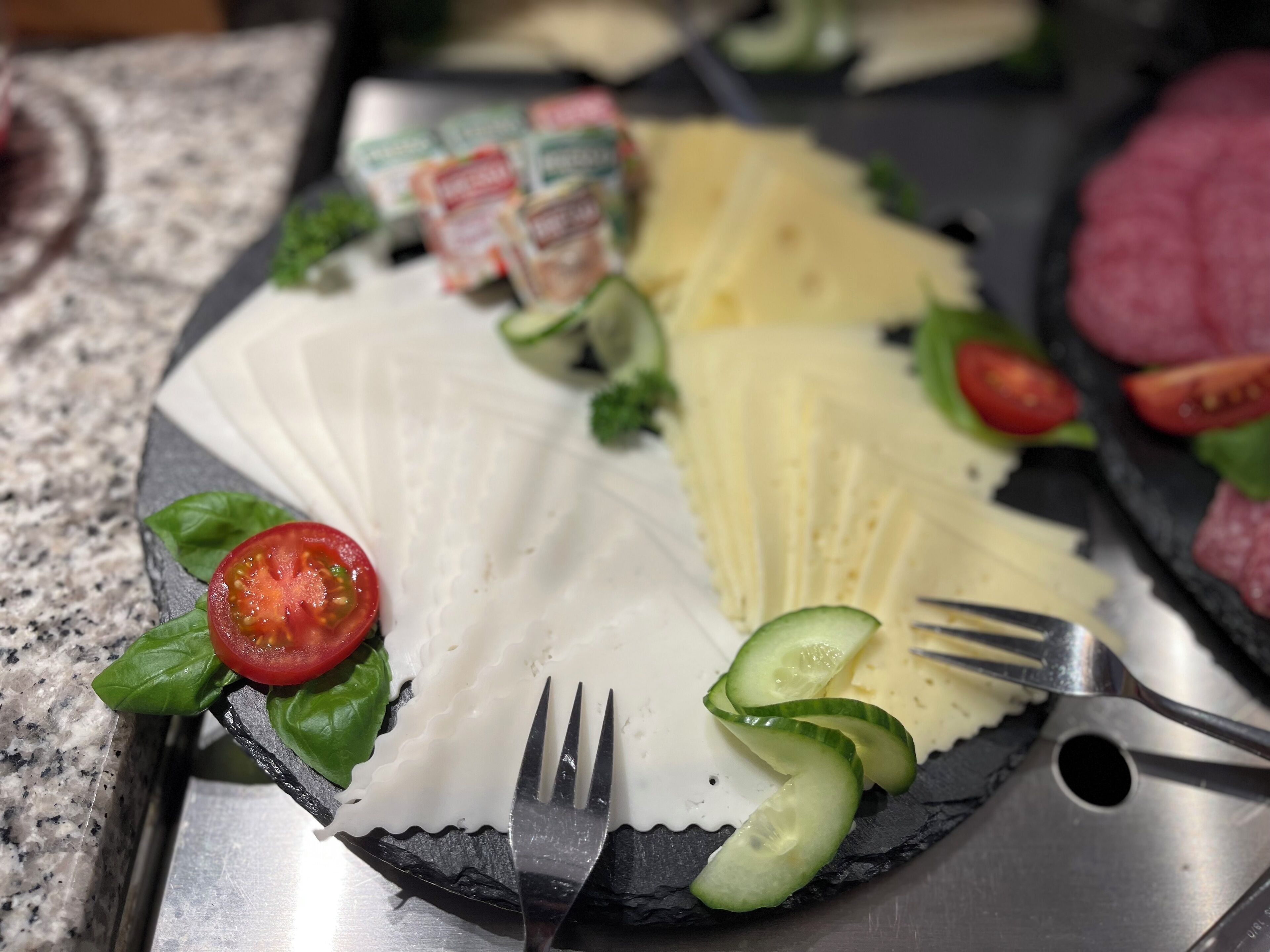 A plate of food with various toppings including cheese, tomatoes, cucumbers, and greens.
