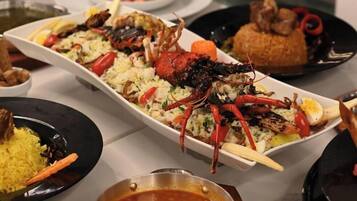 A variety of dishes including seafood, rice, and a bowl of soup.