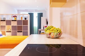 A modern kitchen with a countertop, a bowl of fruit, and a view into the living area. - Bis Studio Apartment 4 (Dubrovnik)
