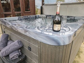 Una vasca idromassaggio con una bottiglia di Prosecco e dei bicchieri.