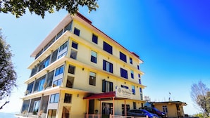 Un hôtel à plusieurs étages, doté de balcons, d’un auvent rouge et d’une enseigne portant le nom « The Radiance ».