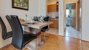 Ein Essbereich mit Holztisch, schwarzen Stühlen und einem Gemälde an der Wand.