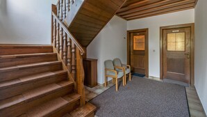 A wooden staircase with a handrail, a carpeted floor, two chairs, and a door labeled "Privat". - Nice apartment in Bad Kleinkirchheim (Bad Kleinkirchheim)