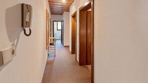 A narrow hallway with wooden doors and a telephone on the left wall. - Nice apartment in Bad Kleinkirchheim (Bad Kleinkirchheim)