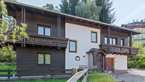 A traditional wooden building with a balcony, a small garden, and a gravel driveway. - Nice apartment in Bad Kleinkirchheim (Bad Kleinkirchheim)