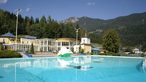 A swimming pool with a boat, surrounded by buildings and mountains. - Chalet in Koetschach-Mauthen near ski slope (Kötschach-Mauthen)