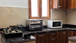A kitchen with a gas stove, a toaster, and a microwave. - Best hotel with Best View AC, WiFi in wonderful Mussoorie (Mussoorie)
