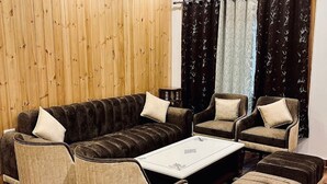 A living room with a sofa, two armchairs, a coffee table, and a rug. - Best hotel with Best View AC, WiFi in wonderful Mussoorie (Mussoorie)