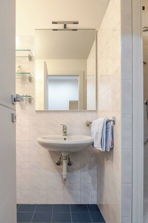 A modern bathroom with a white sink, a mirror, and a towel rack. - Hotel 3 Comfort and Serenity Heart of Ventimiglia (Ventimiglia)