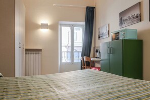 A hotel room with a bed, a desk with a chair, a green wardrobe, and a window with a view. - Hotel 3 Comfort and Serenity Heart of Ventimiglia (Ventimiglia)
