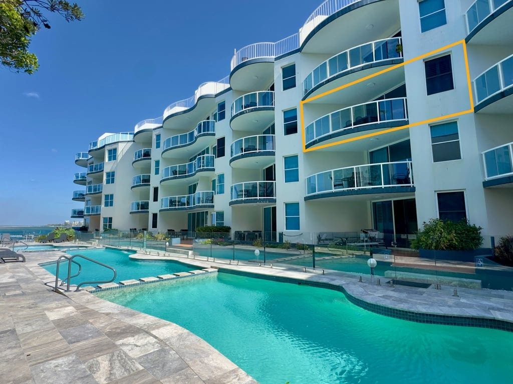 Ein mehrstöckiges Hotel mit Balkonen, einem Schwimmbad und freiem Blick auf den Ozean.