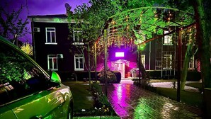 A car parked in a driveway with a house in the background. - Armon Apart Hotel (Khujand)